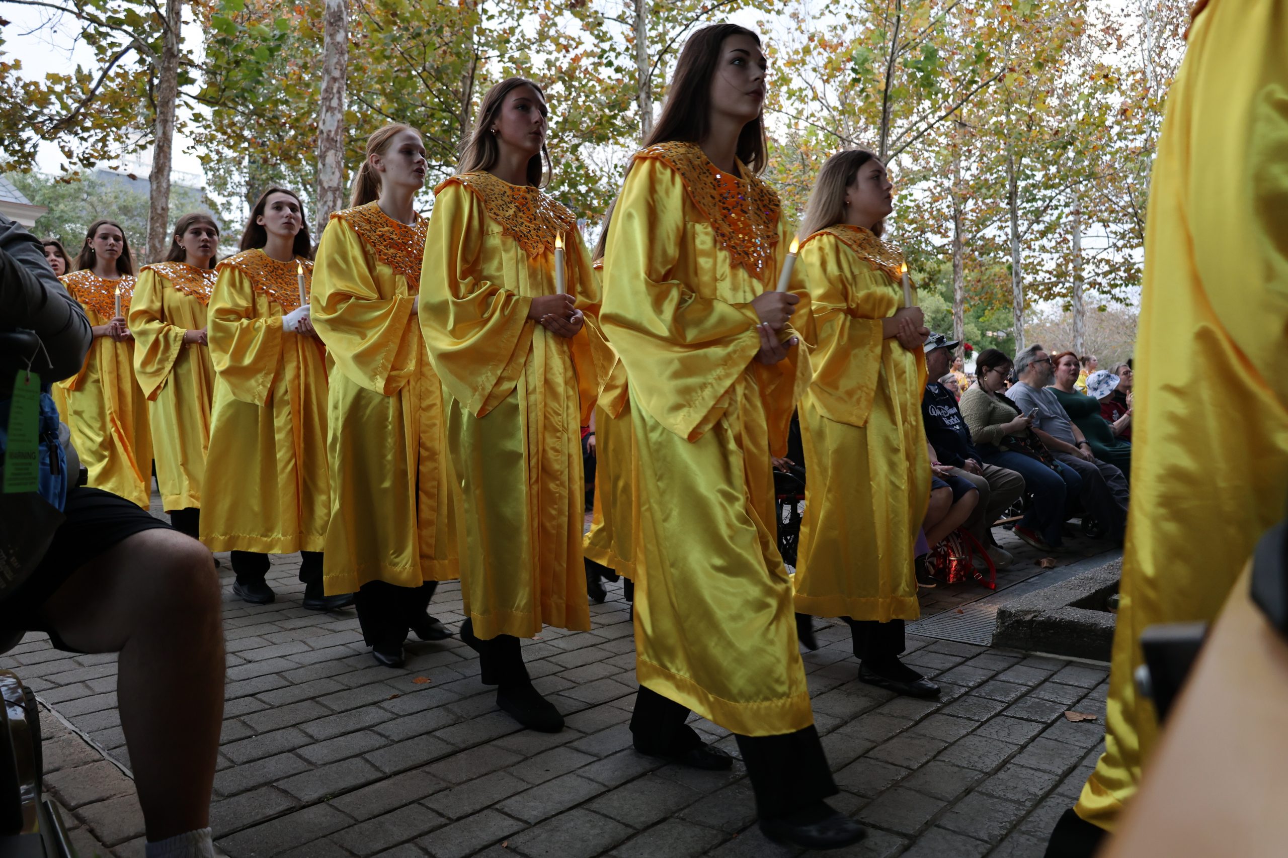 Choir student performers processing to the stage for their performance holding candles