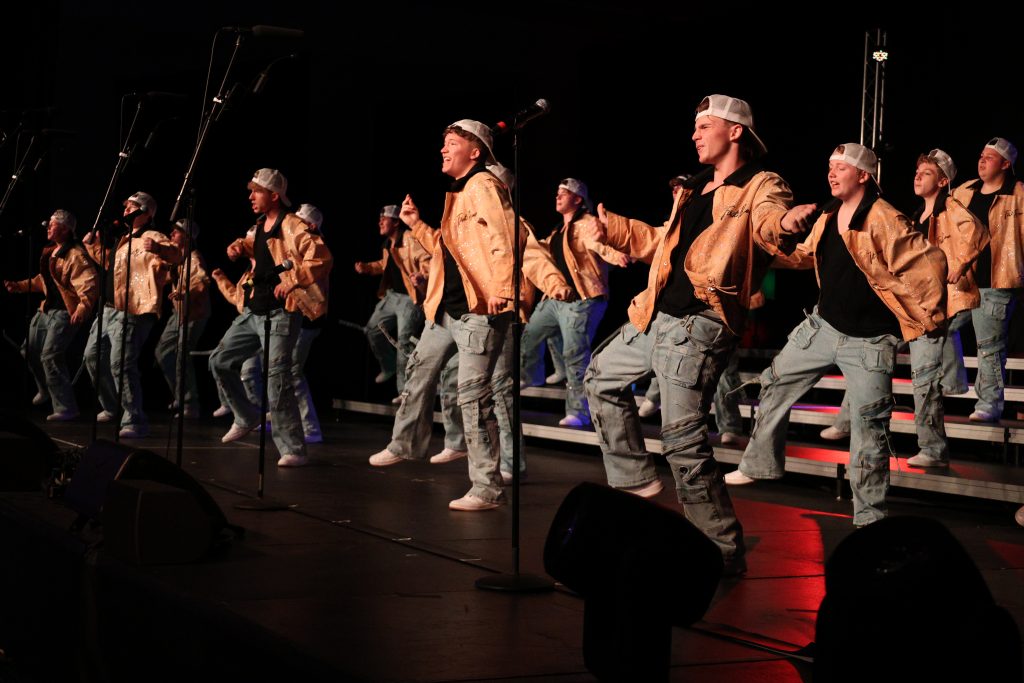 Mt. Zion High School's You've Got Male performing in orange jackets, baggy jeans and white baseball caps