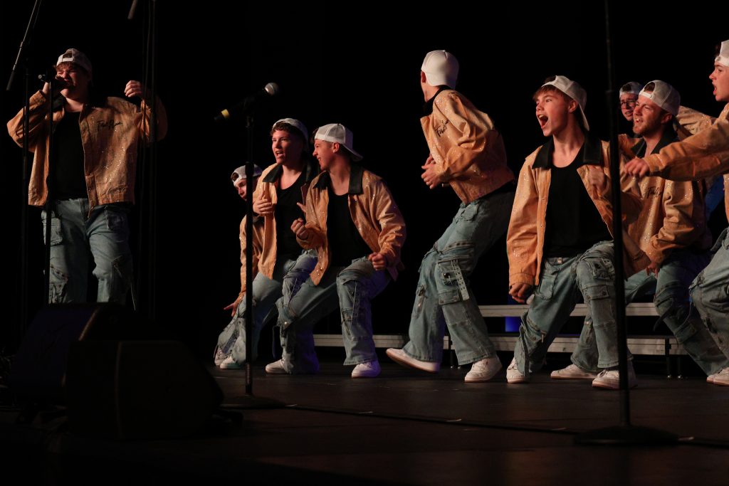 Mt. Zion High School's You've Got Male performing in orange jackets, baggy jeans and white baseball caps