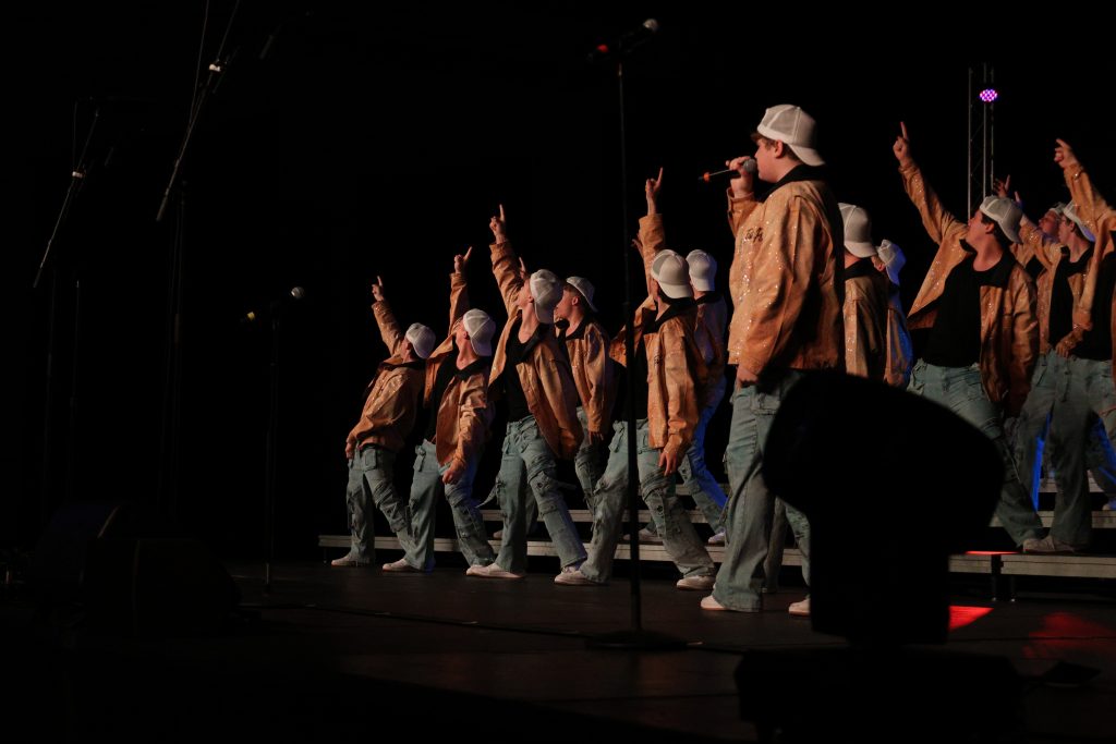 Mt. Zion High School's You've Got Male performing in orange jackets, baggy jeans and white baseball caps